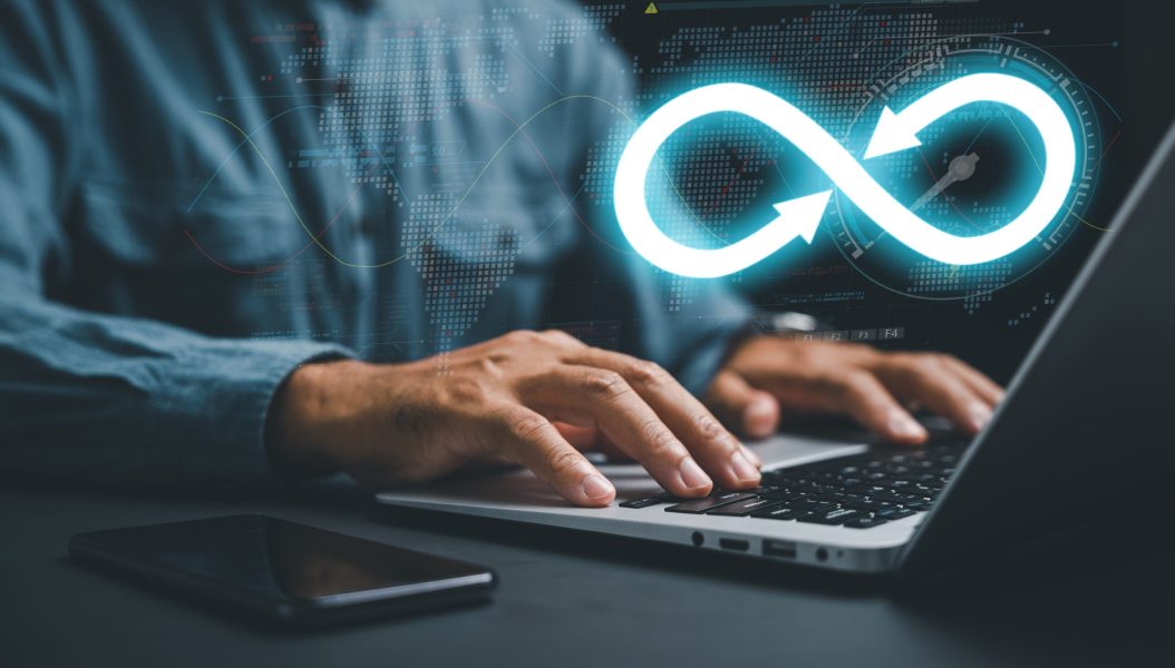 DevOps engineer in agile environment. infinity icon on computer, coder typing. Integration of software development IT operations. concept of continuous integration. technology infinity data